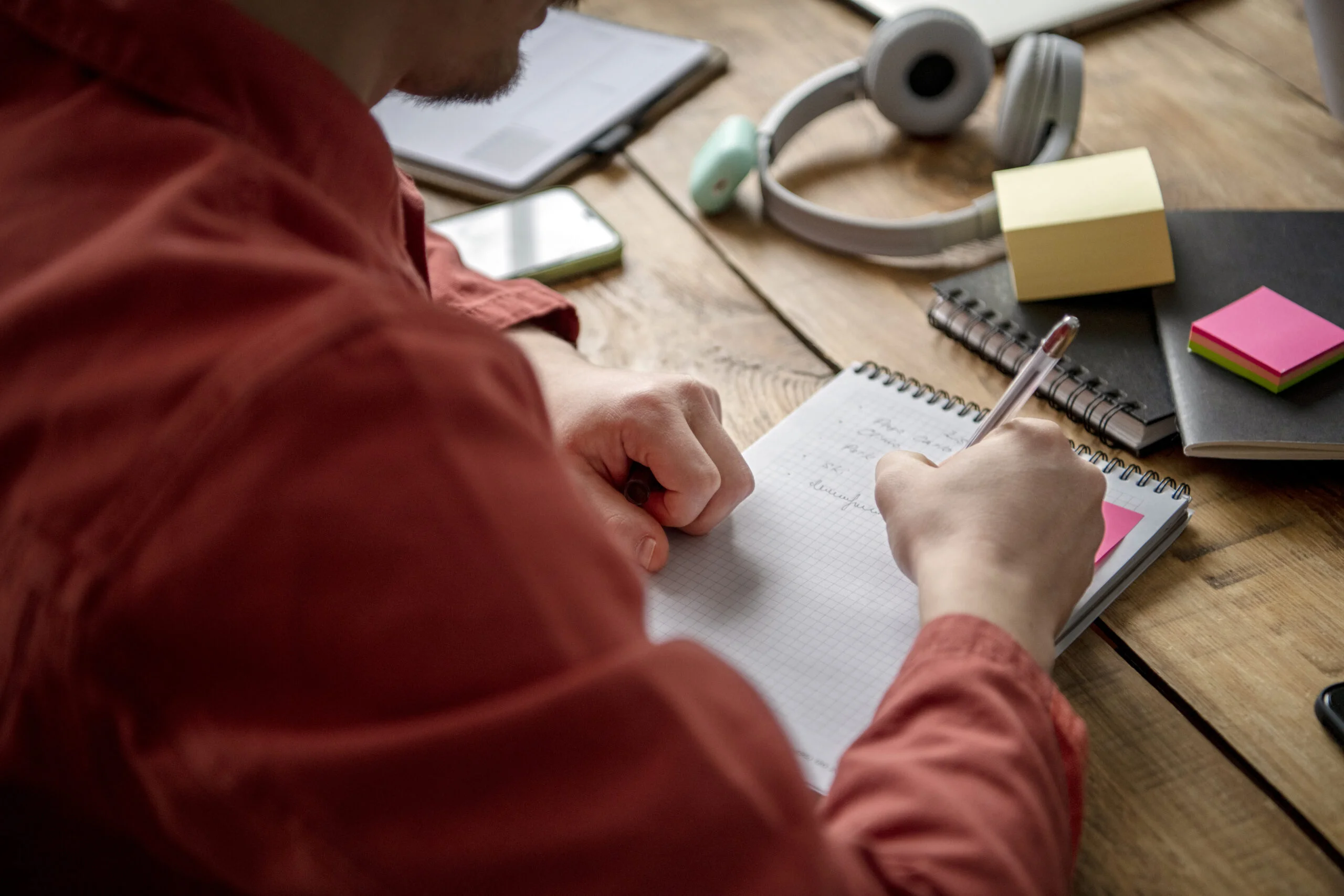 Student writing notes at a desk