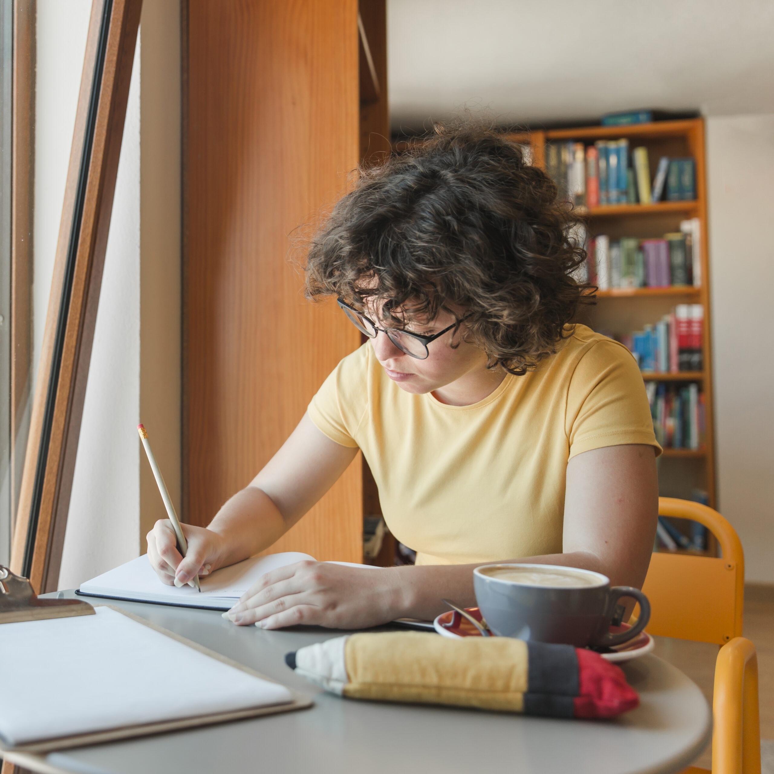 Teenager with coffee studying library